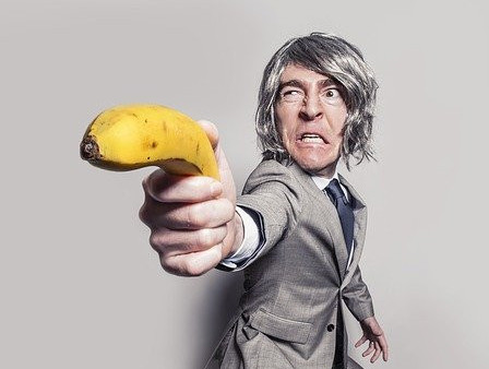 Angry guy pointing a banana gun